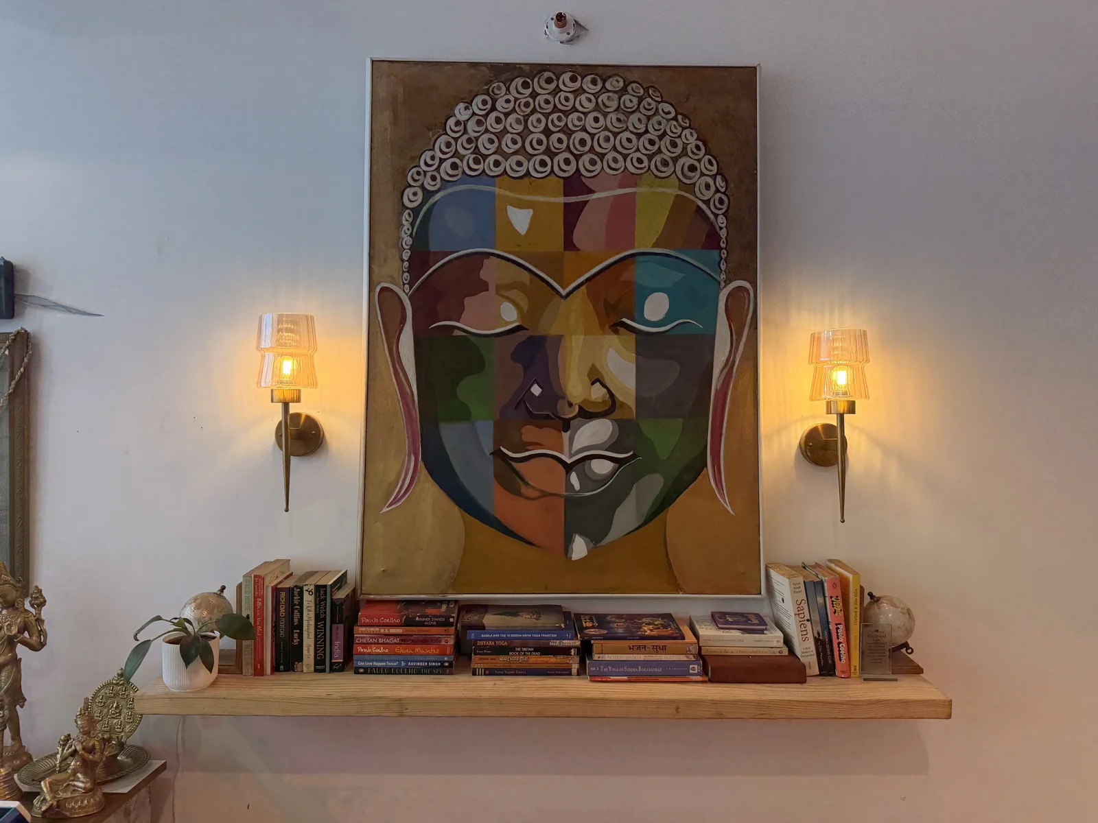 Colourful artwork displayed between warm wall lamps