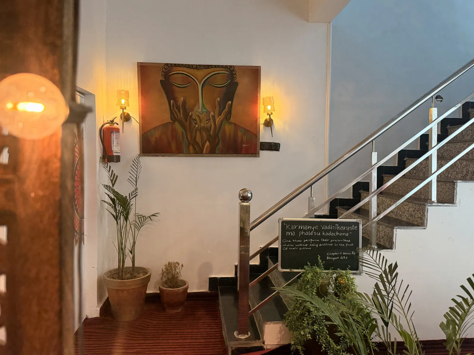 A painting between warm wall lamps beside the stairs
