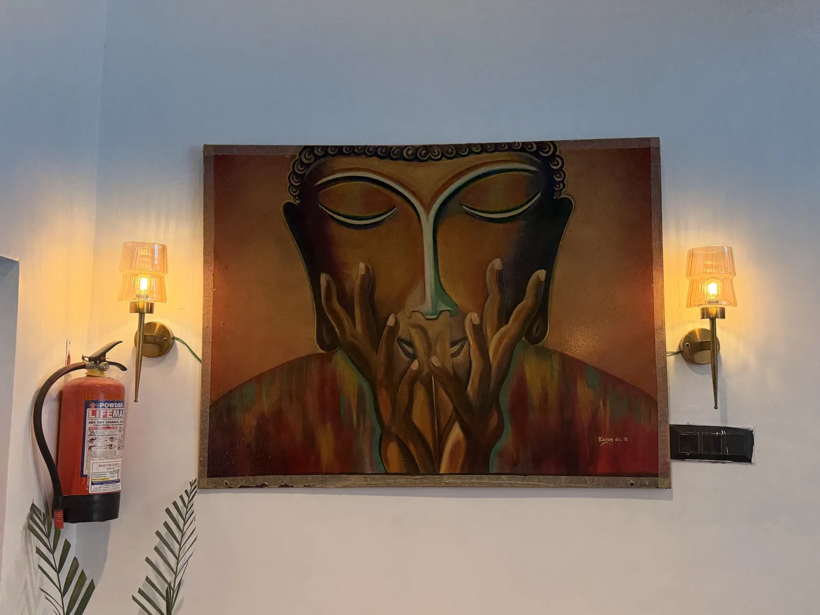 Buddha artwork between two warm lamps