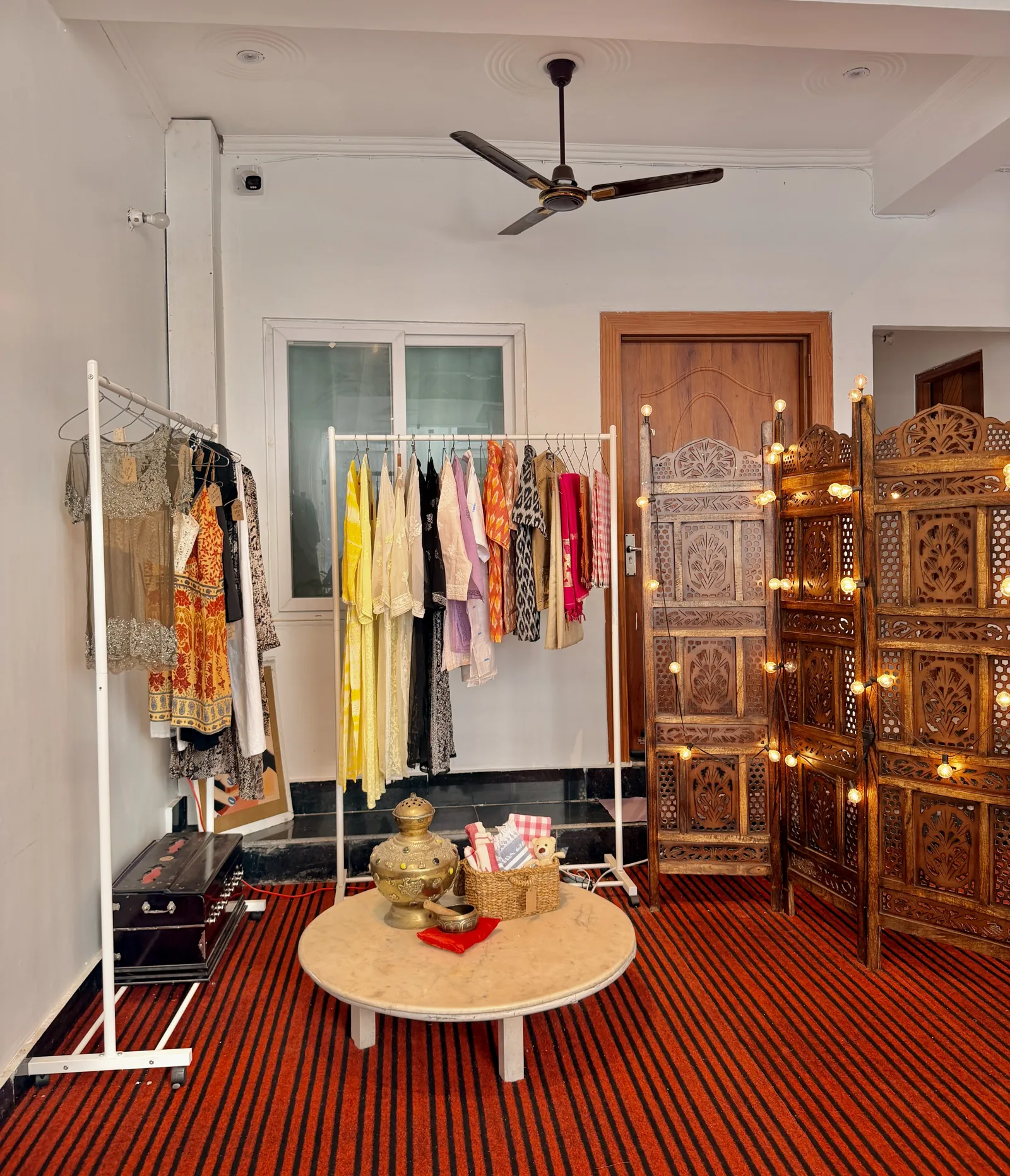 The Sanskriti clothing corner beside a carved wooden screen