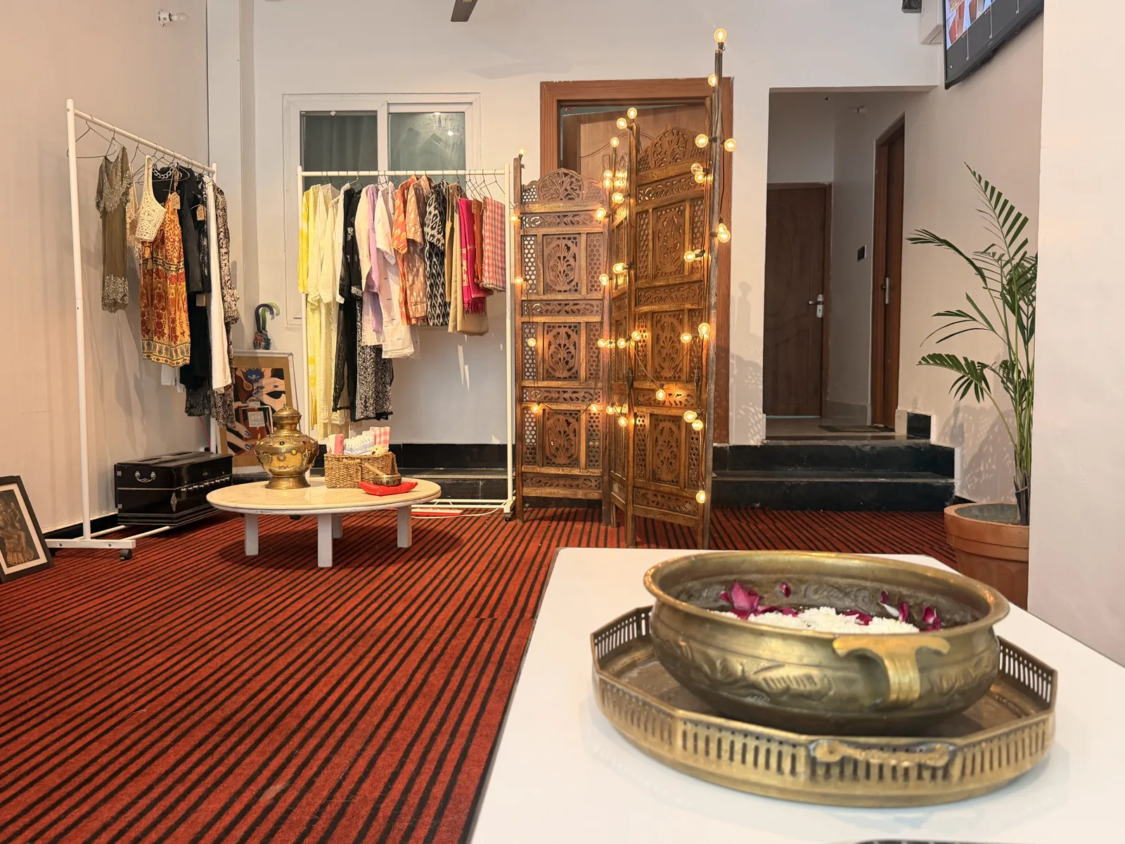 Clothing and a carved wooden screen at Sanskriti