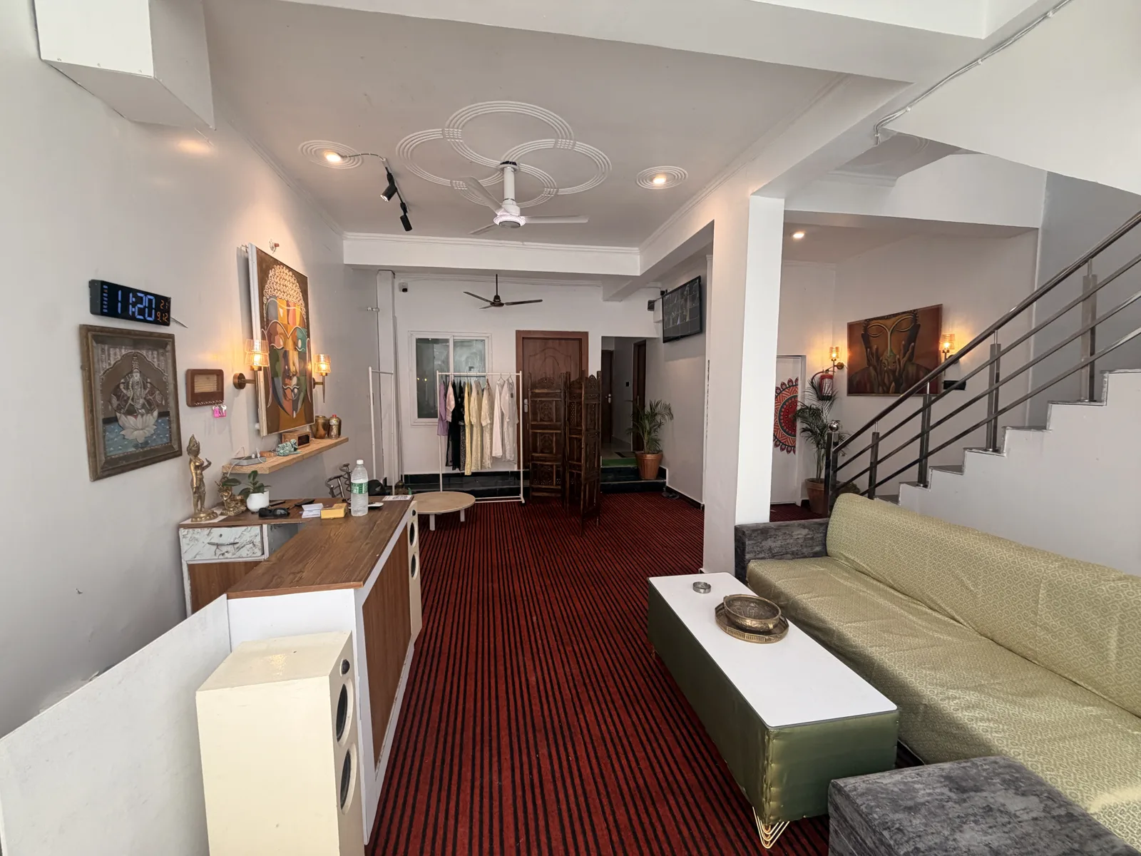 The shared lounge with sage seating and a red carpet