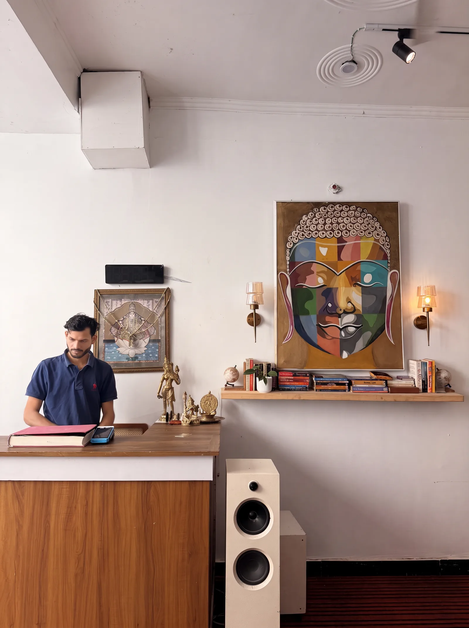 Reception desk with artwork and a speaker at Sanskriti