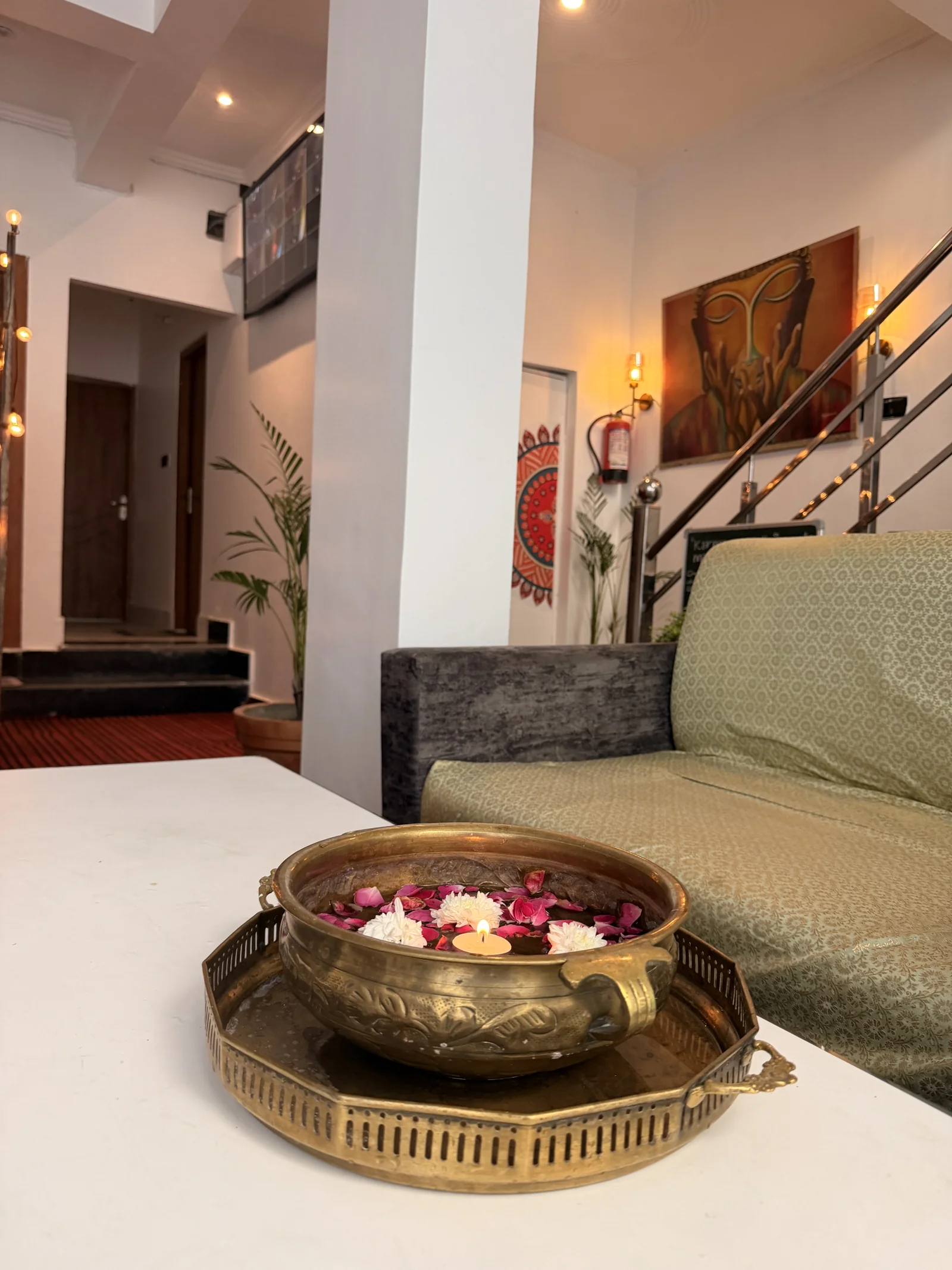 Flowers in a brass bowl beside the lounge seating